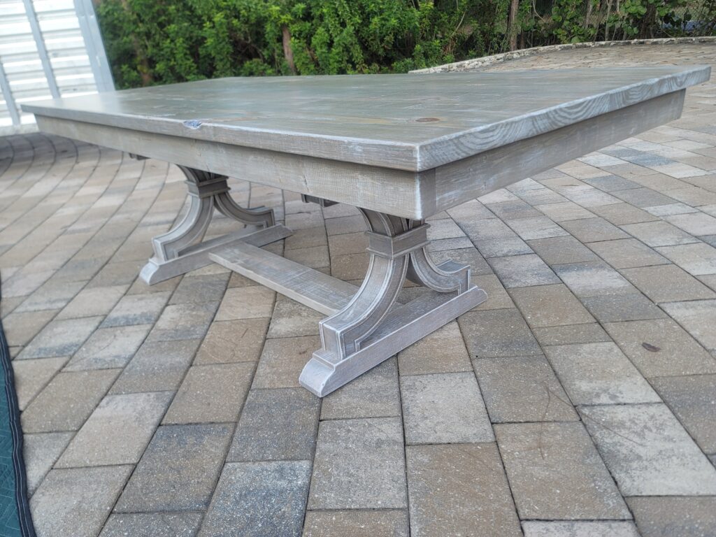 distressed gray and white wash trestle table with curved pedestals